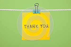 Yellow paper note on clothesline with text Ã¢â¬ÅThank YouÃ¢â¬Â